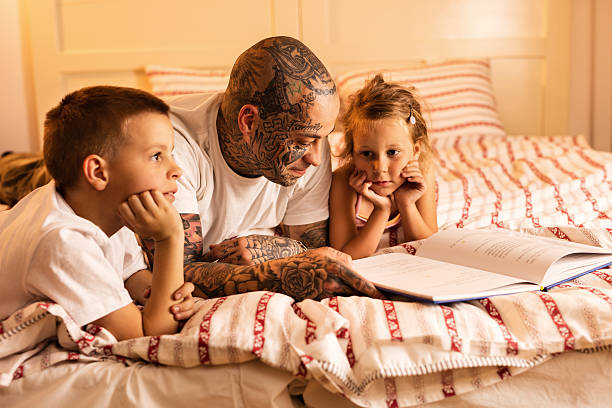 istock Children feeling bored while their father is reading them story. 543076380