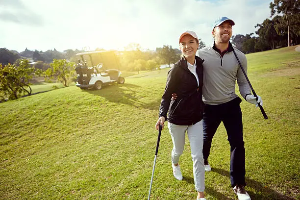 Shot of a smiling young couple enjoying a day on the golf course