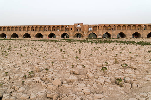Isfahan, Iran - April 24, 2017: The full-flowing river Zayandeh in April, and the Allahverdi Khan bridge with resting townspeople.