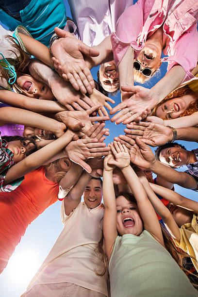 poniżej widok szczęśliwych ludzi pracy ich ręce w jedności. - human hand holding hands hands clasped group of people zdjęcia i obrazy z banku zdjęć