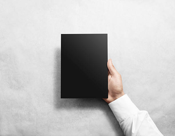 istock Hand holding blank black brochure booklet mockup. 543082186