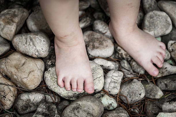 le pied de l’enfant apprend à marcher sur des cailloux, massage de réflexologie - stepping stone stone stepping footpath photos et images de collection