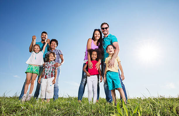 istock Two happy mixed race families standing against the sky. 543084874