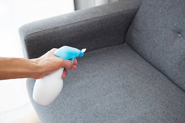 istock Sprayed air freshener in hand on home interior background 543085118