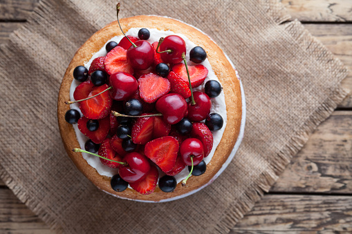 Fresh raw strawberry cake homemade traditional summer gourmet sweet dessert bakery food decorated with berries and whipped cream on rustic background table