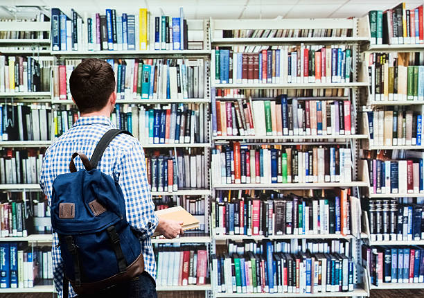 istock Rear view of student holding books in library 543087166
