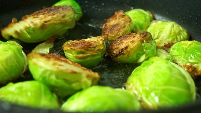 Turning over fried Brussels sprouts close up shot
