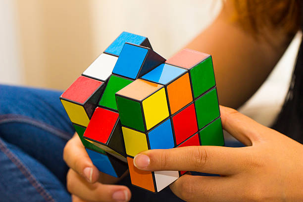 Teenager playing magic cube Eskisehir, Turkey - June 26th, 2016: This classic Rubik's Cube is a 3-D mechanical puzzle invented by a Hungarian sculptor and professor of architecture Ernő Rubik in year 1974. puzzle cube stock pictures, royalty-free photos & images