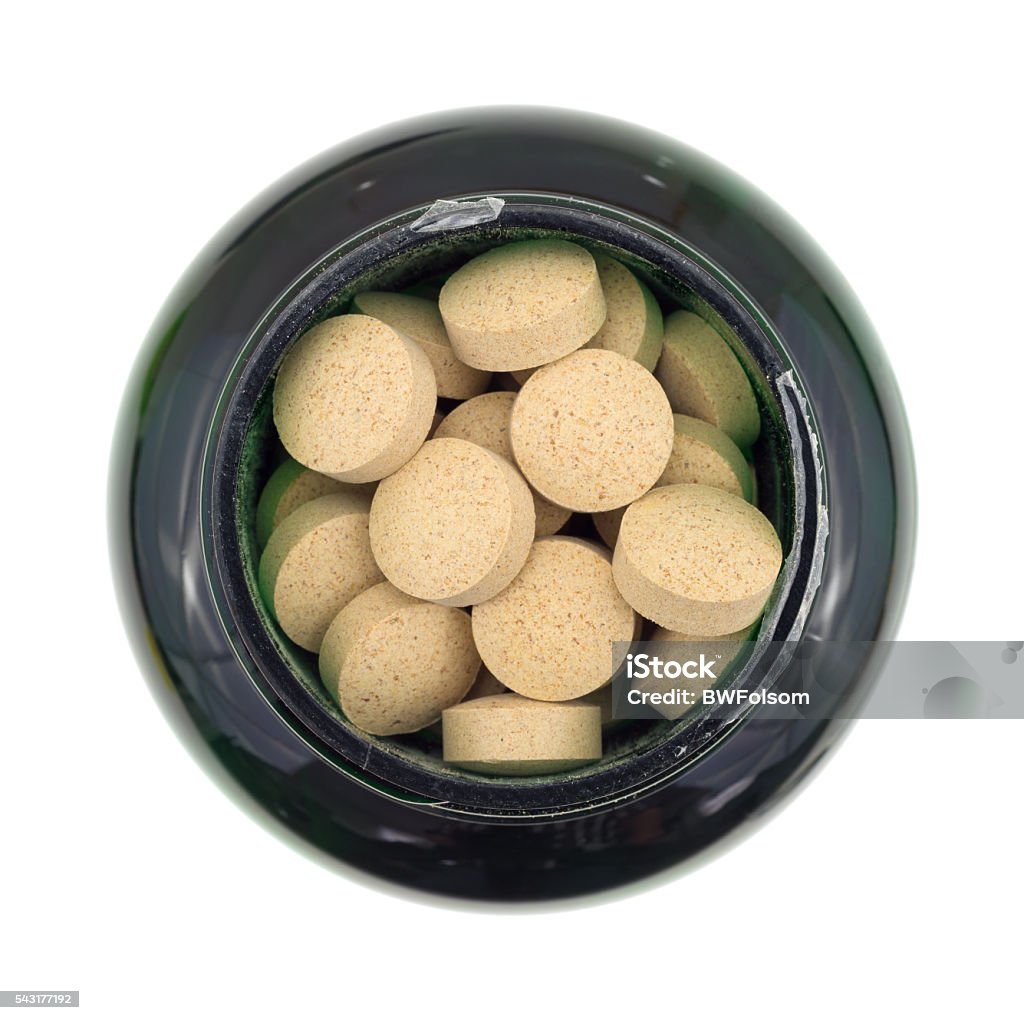 Brewer's yeast nutritional supplement in a bottle Top view of an opened bottle of brewer's yeast nutritional supplement isolated on a white background. Nutritional Supplement Stock Photo