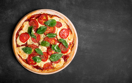 Pizza (margherita) on the chalk board with copy space