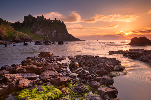 The ruins of the Dunluce Castle on the Causeway Coast of Northern Ireland. Photographed at sunset.