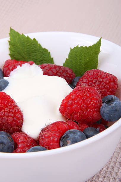 istock fresh raspberries and berry with cream and sugar on a bowl 543179560