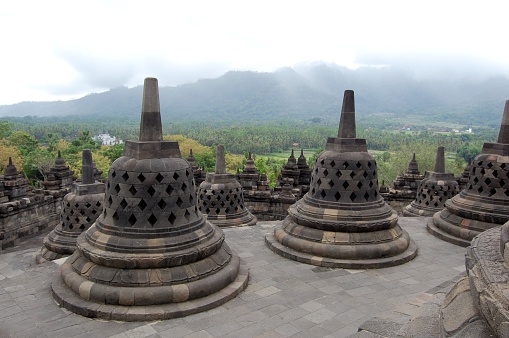 Stupas on top of the Borobudur temple, surrounding the green valley in central Java. It's a popular tourist destination in the indonesian island. It is the world’s largest Buddhist temple, as well as one of the greatest Buddhist monuments in the world.