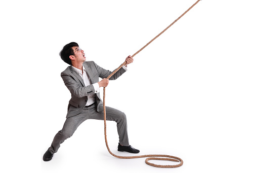 African businessman pulling a rope on white background