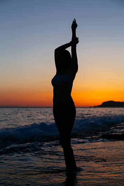 istock Sexy slender woman posing against sunset at beach 543183508