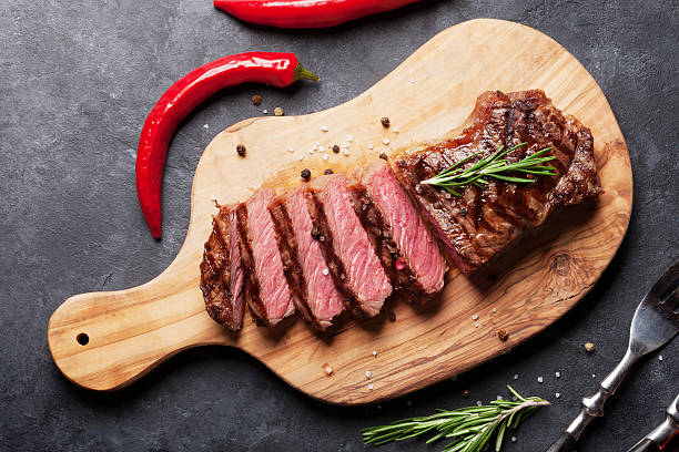 Grilled sliced beef steak Grilled sliced beef steak on cutting board over stone table. Top view roast beef photos stock pictures, royalty-free photos & images
