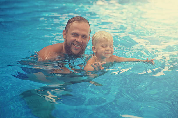 istock Father and son playing in the pool 543187696