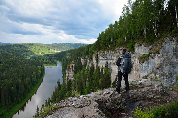istock man with backpack stands on top of the mountain. 543188126