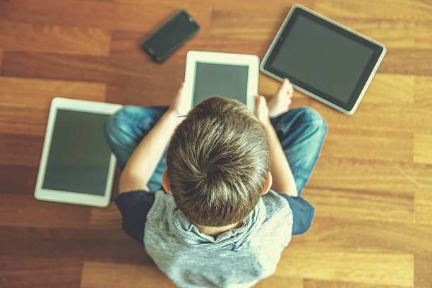 istock Little boy using tablet sitting on wooden floor. Digital tablets 543188856