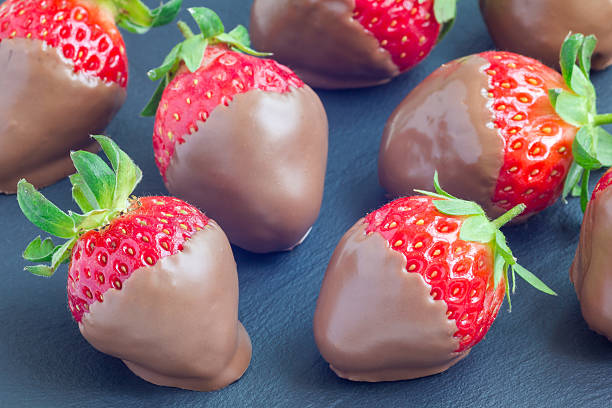 istock Strawberries covered with milk chocolate on a grey slate, stone 543192628