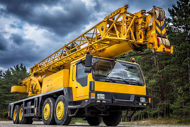 Yellow mobile crane in road construction Yellow mobile crane in road construction crane truck stock pictures, royalty-free photos & images