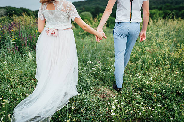 istock Happy Bride and groom walking on the green grass 543196046