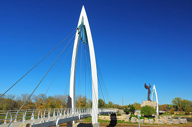Keeper of the Plains Suspension Bridge and Statue Wichita, United States - October 19, 2012: Keeper of the Plains Suspension Bridge, with the Keeper of the Plains Statue and the second section of the bridge in the background. wichita photos stock pictures, royalty-free photos & images