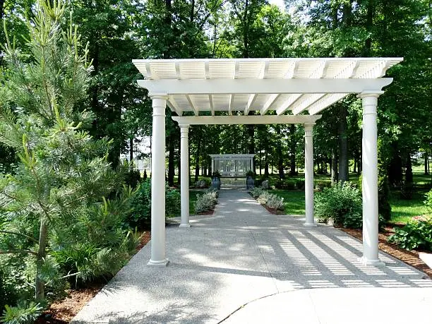 gazebo on concrete path surrounded by nature and gardens