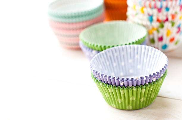 istock empty cupcake paper liners, cases on white wooden board 543197240