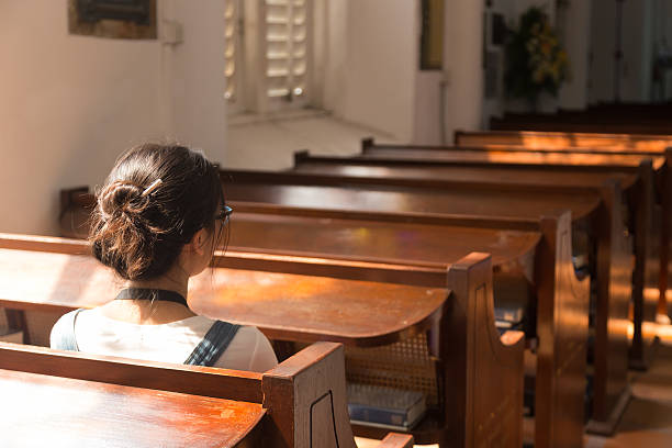 istock One woman sitting in church. 543198518
