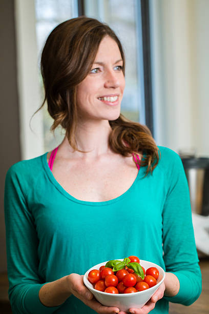 Young woman showing a cherry tomatoes