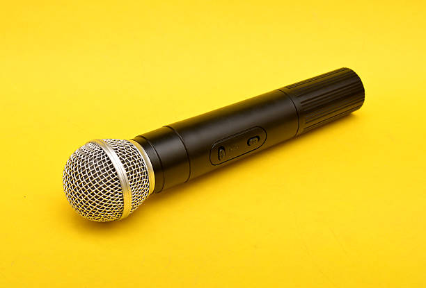 istock Wireless microphone on a yellow background - Motivational Speaker concept 543204228