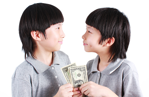 Portrait of two boys, twins holding money isolated on white.