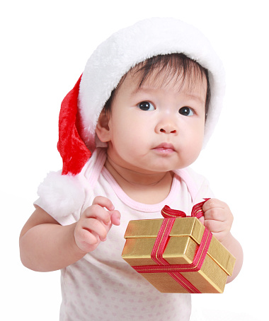 Little baby celebrates Christmas. New Year's holidays. Baby in a Christmas costume with gift
