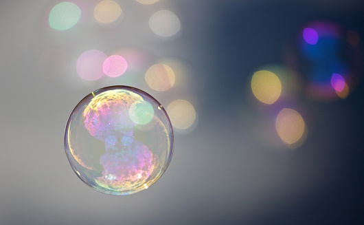 one in the foreground floating bubble with unschafen colorful bubbles in the background