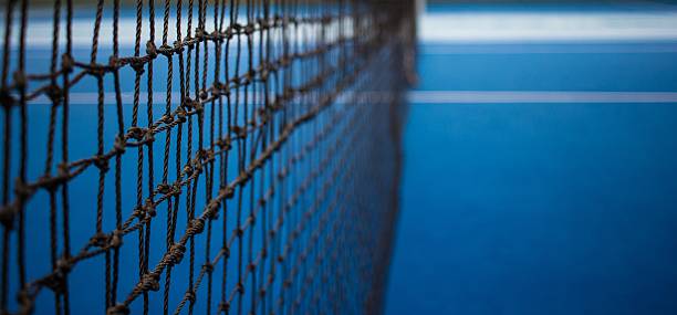 red de tenis y cancha azul. - tennis court tennis net indoors fotografías e imágenes de stock