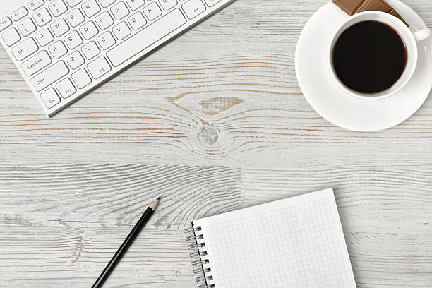 istock Workplace with cup of coffee, keyboard, smarthphone, white sheets and 543212608