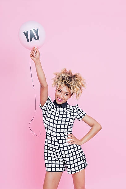 istock Young woman holding YAY balloon 543212640