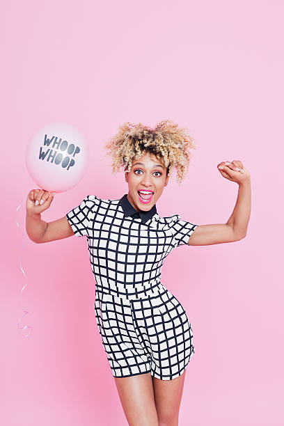 istock Young woman holding YAY balloon 543212736