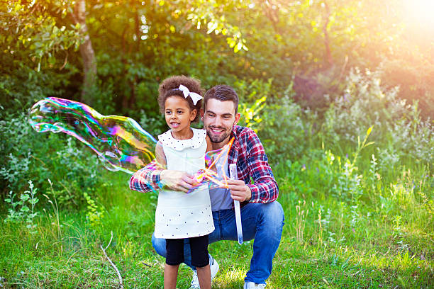 istock Happy father and daughter playing soap bubbles in park. 543214254
