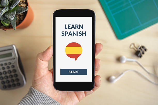 hand holding smart phone with learn spanish concept on screen - spanish culture teacher learning text imagens e fotografias de stock