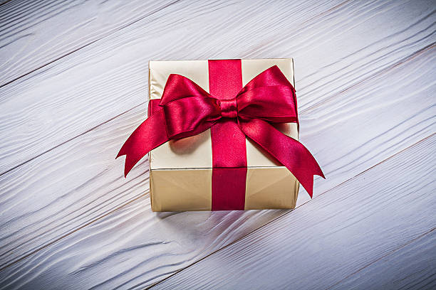 istock Birthday gift box with red ribbon on wooden board holidays 543218896
