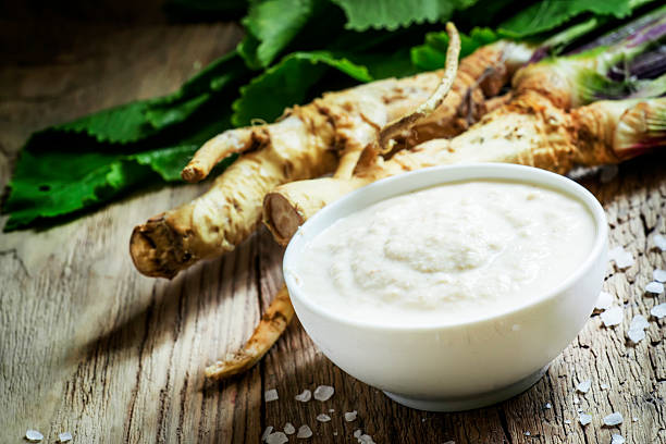 Ground horseradish Ground horseradish, hot sauce to the food in a white bowl, roots and leaves of fresh horseradish, vintage wooden background, selective focus horseradish stock pictures, royalty-free photos & images