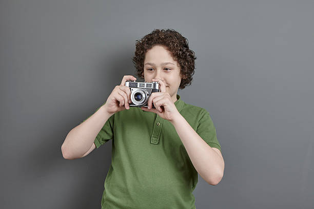 istock Cute boy taking photo with a retro camera 543220588