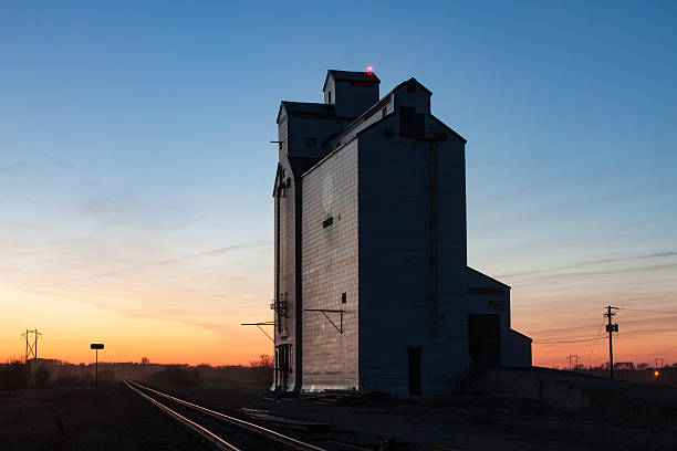 istock Wooden grain elevator and tracks against prairie sunset 543317906