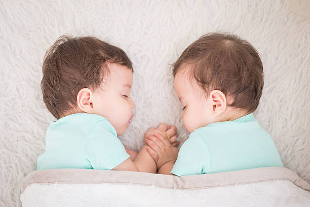 baby twins sleeping Newborn beautiful baby twins sleeping with pacifier. Closeup portrait, caucasian child twin stock pictures, royalty-free photos & images
