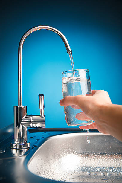 istock hand pouring a glass of water from filter tap 543321704