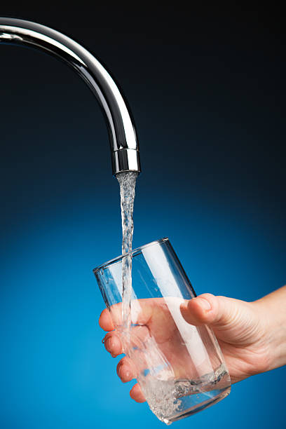istock hand pouring a glass of water from filter tap 543321986