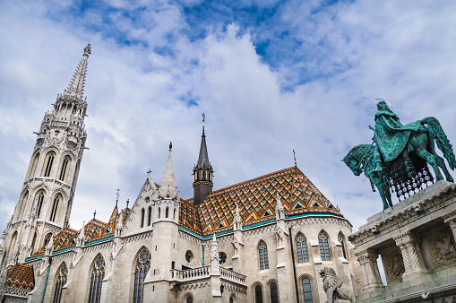 The steeples and spires of Mathias Church in Budapest, Hungary with the statue of the first Hungarian King; King St. Stephen 975-1038.