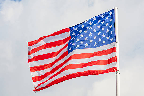 istock Close-up American flag waving against cloudy blue sky background 543324362